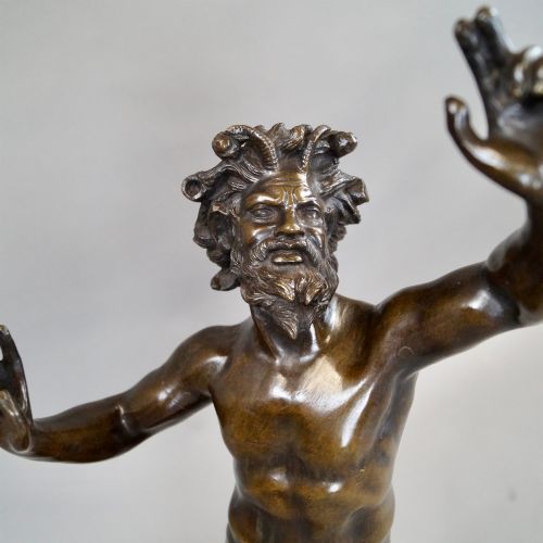 fig 1. A late nineteenth-century dark brown patinated bronze sculpture depicting a dancing faun on a square plinth base.