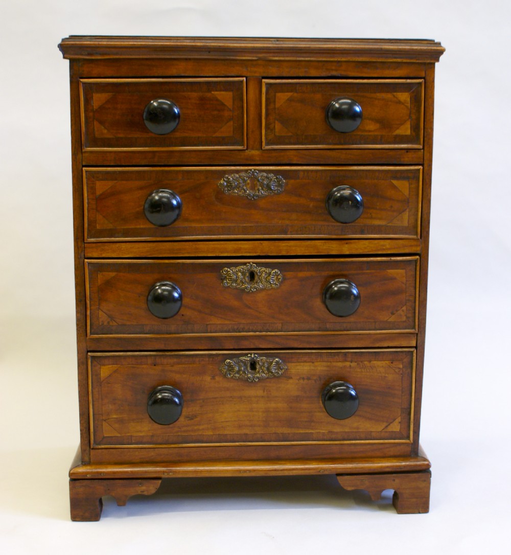 An early 19th century Fruitwood miniature chest of drawers