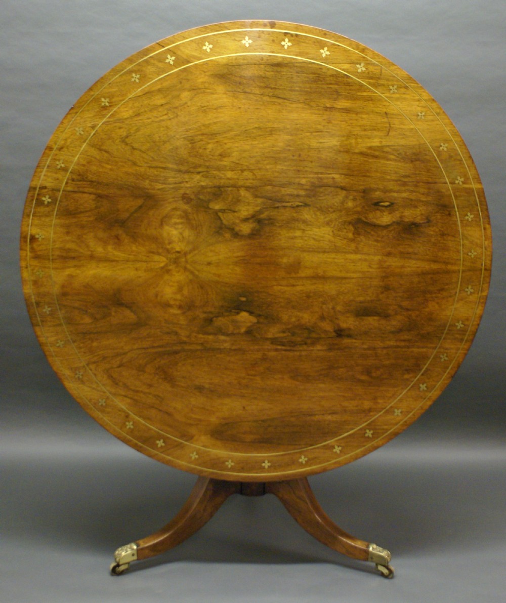 A Regency rosewood and brass inlaid center table