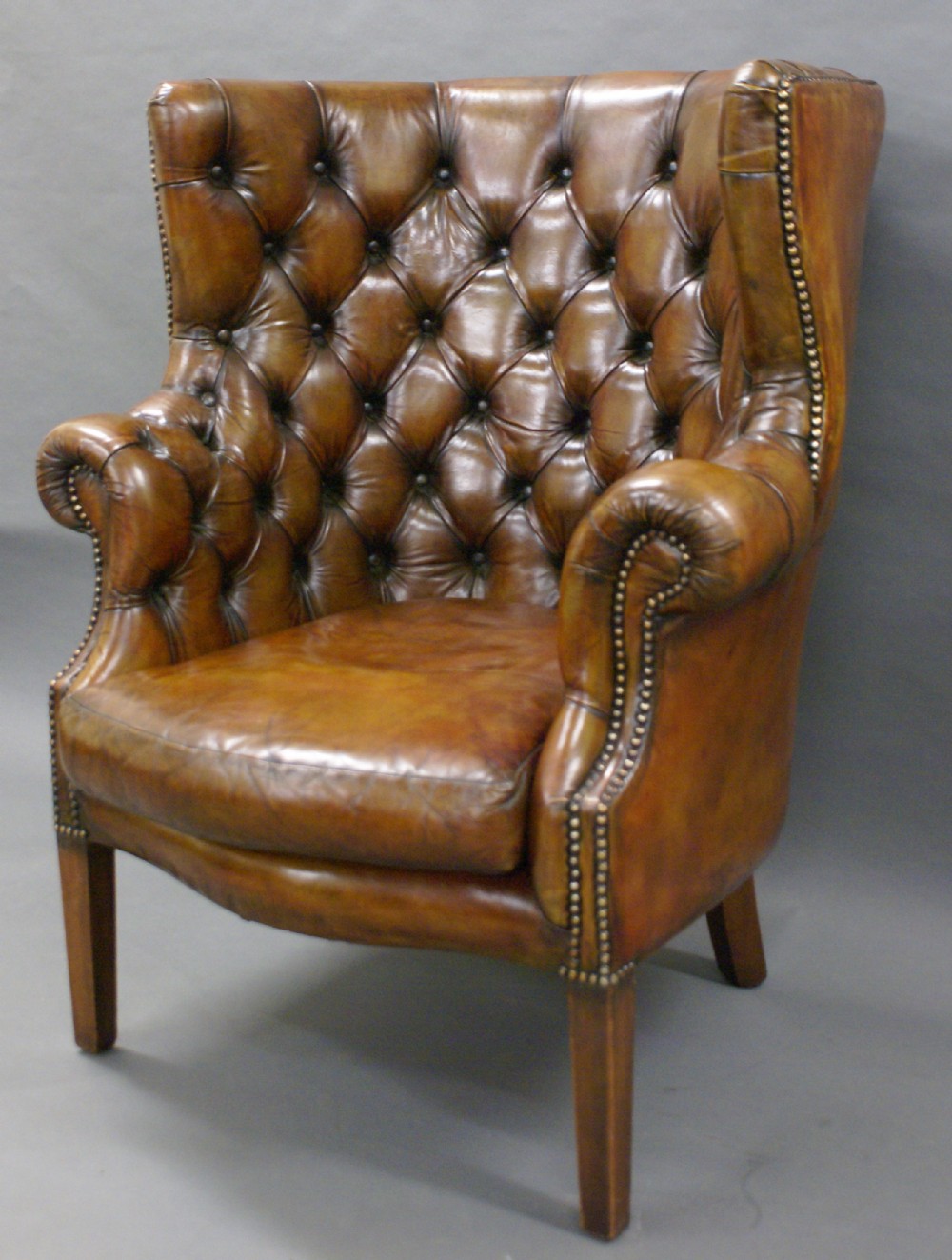 A Georgian Revival leather upholstered barrel back arm chair