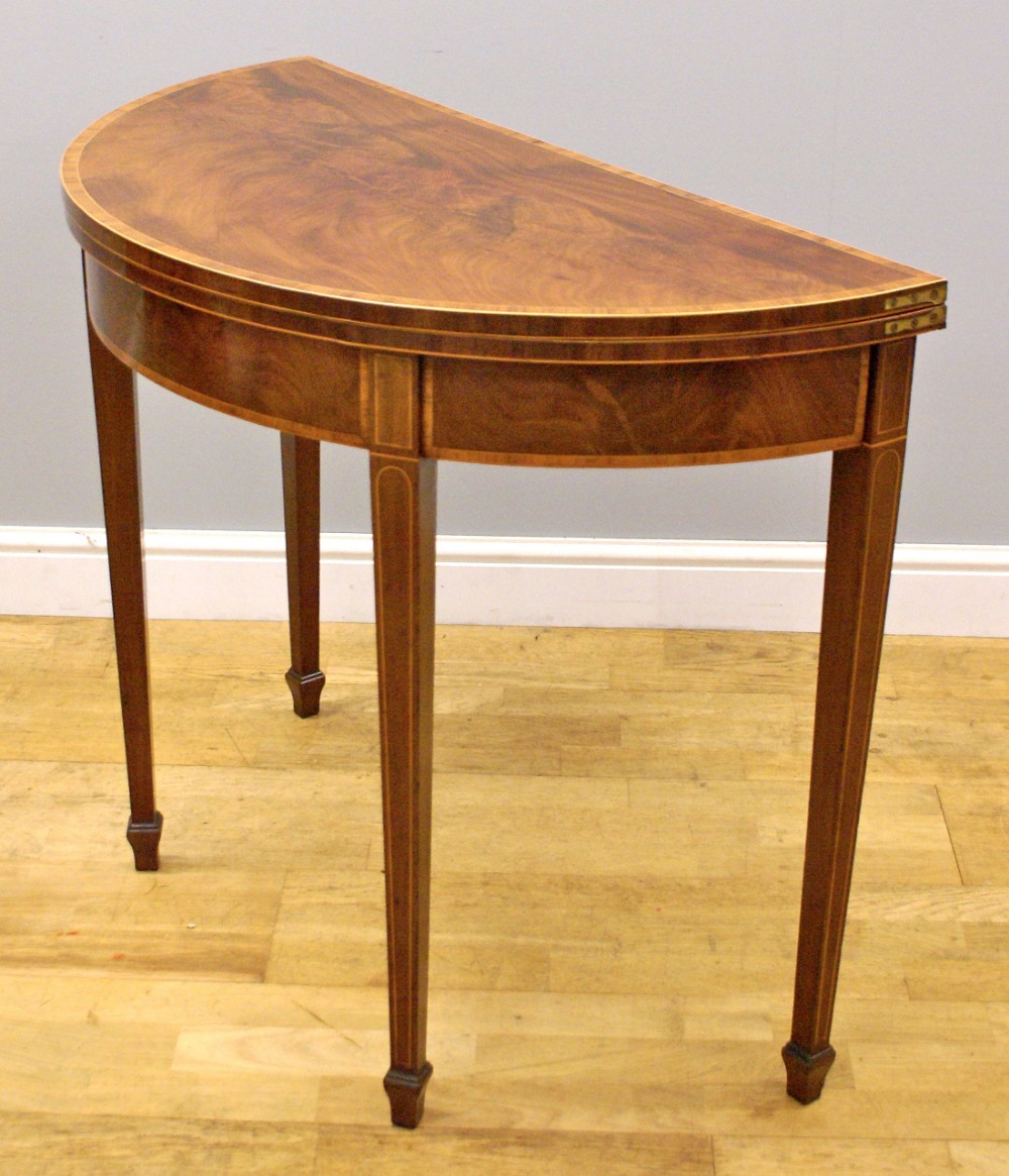 A George III flame mahogany, demi lune card table