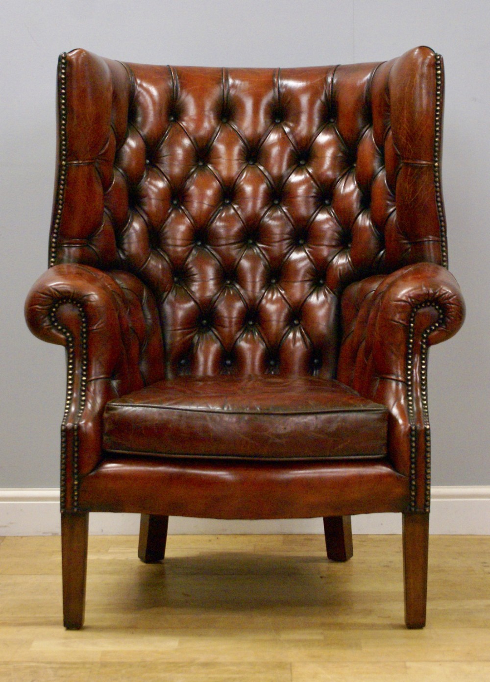 A Georgian style, barrel back, deep buttoned wing chair