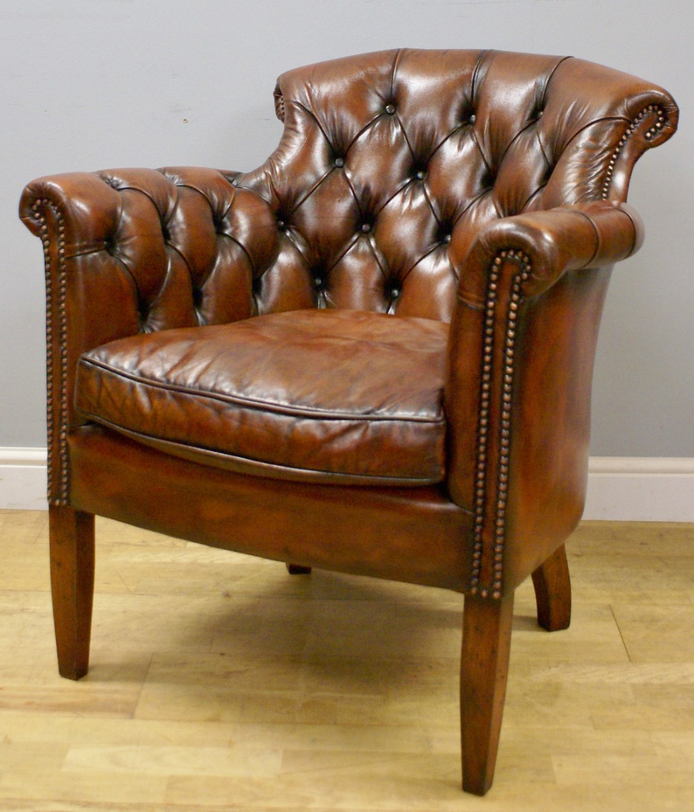 A Georgian style buttoned leather arm chair