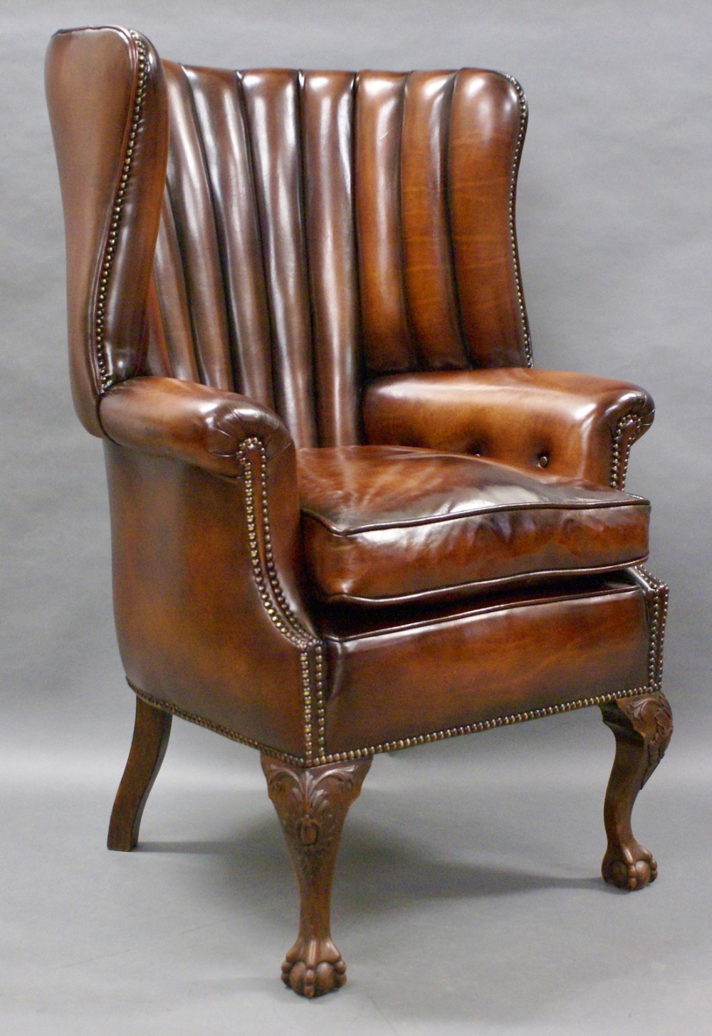 A George II style leather upholstered wing chair