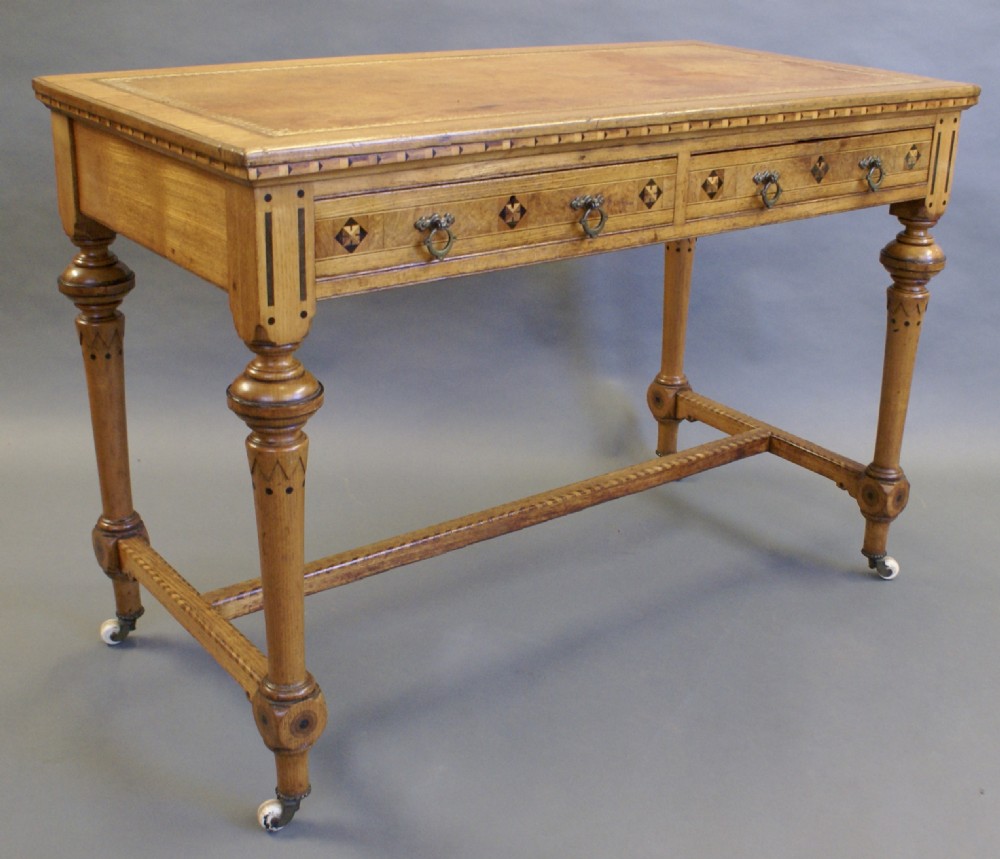 An Arts & Crafts inlaid writing table in the manner of Shoolbred.
