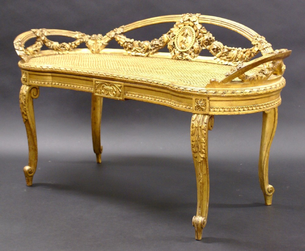 An Italian carved wood, gilt window seat