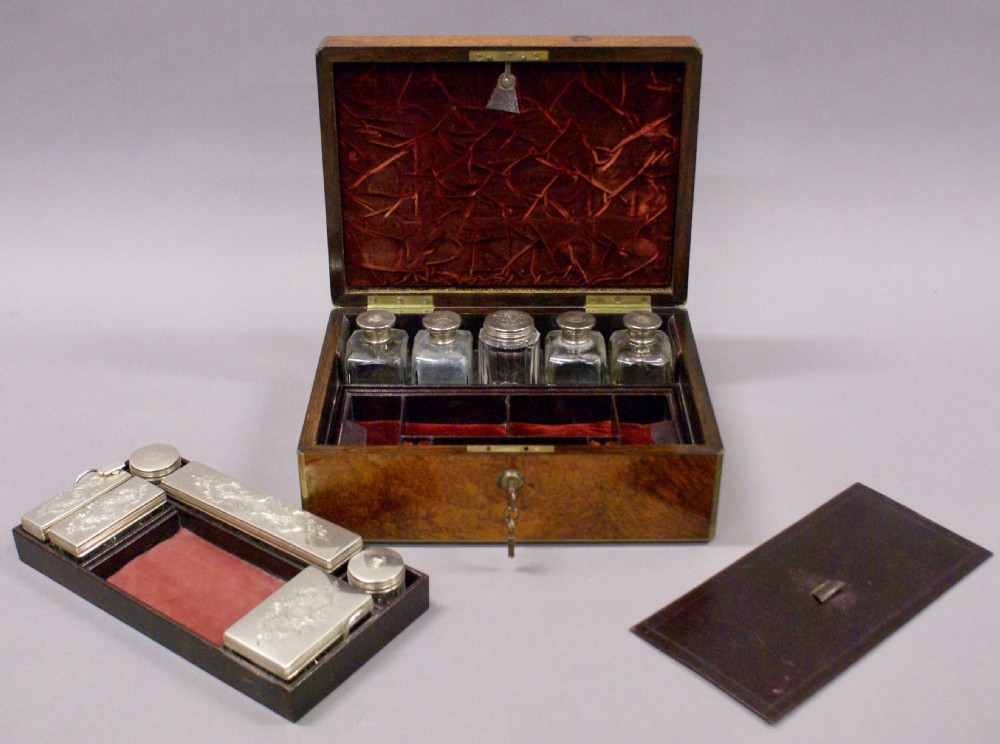 A rectangular 19th-century amboyna wood dressing box with brass bindings, a central brass cartouche, flush side handles, and an inserted steel key. View IV