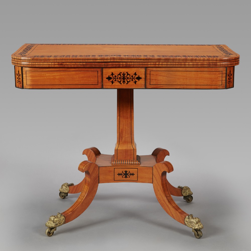 A 19th century late Regency Period satinwood and ebony inlaid pedestal card table.