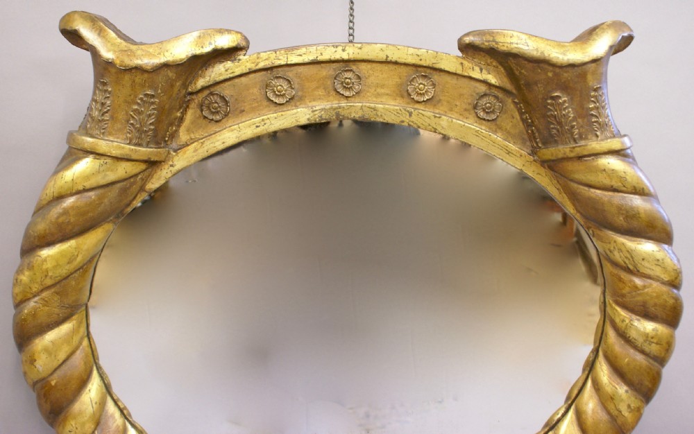 An Italian lacca a mecca giltwood wall mirror featuring a carved rope twist frame with cornucopia and stylised dolphin motifs. View II