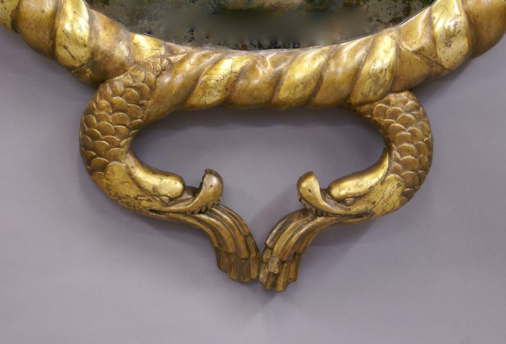 An Italian lacca a mecca giltwood wall mirror featuring a carved rope twist frame with cornucopia and stylised dolphin motifs. View III