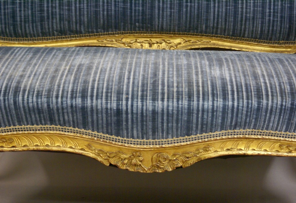 A 19th-century French Rococo-style giltwood sofa featuring a carved gold-leaf frame, cabriole legs, and blue striped fabric upholstery. View VI