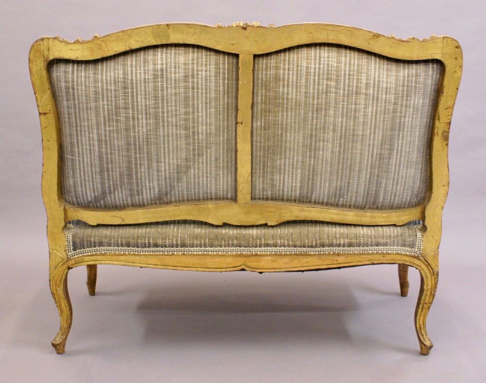 A 19th-century French Rococo-style giltwood sofa featuring a carved gold-leaf frame, cabriole legs, and blue striped fabric upholstery. View VII