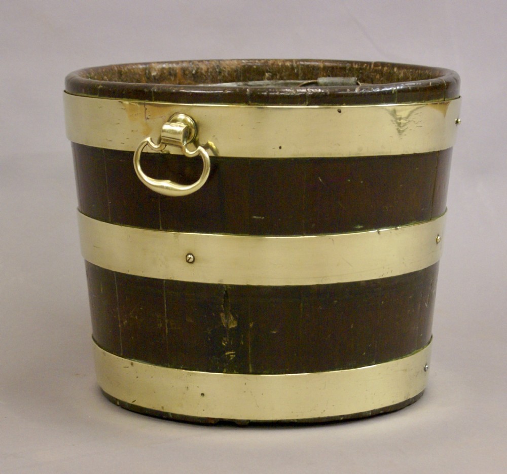 A cylindrical George III mahogany bucket with three horizontal brass bands and brass drop-ring side handles. View II