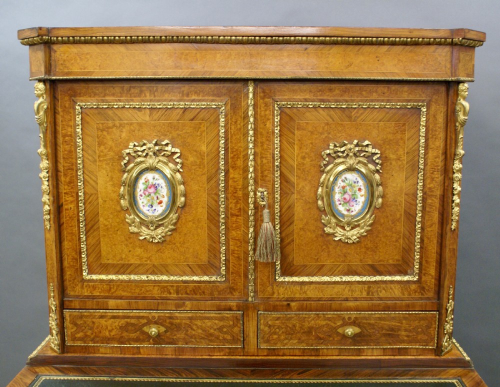 A nineteenth-century French bonheur du jour writing desk constructed from golden walnut veneer with gilded bronze mounts, cabriole legs, and inset hand-painted porcelain plaques. View V
