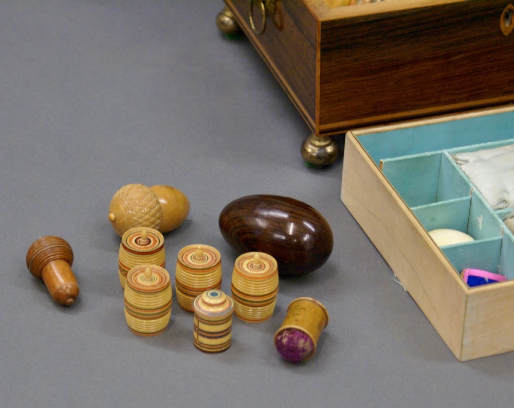 A rectangular dark rosewood Regency sewing box featuring brass ball feet, lion-mask side ring handles, and floral marquetry inlay across the lid. View VII