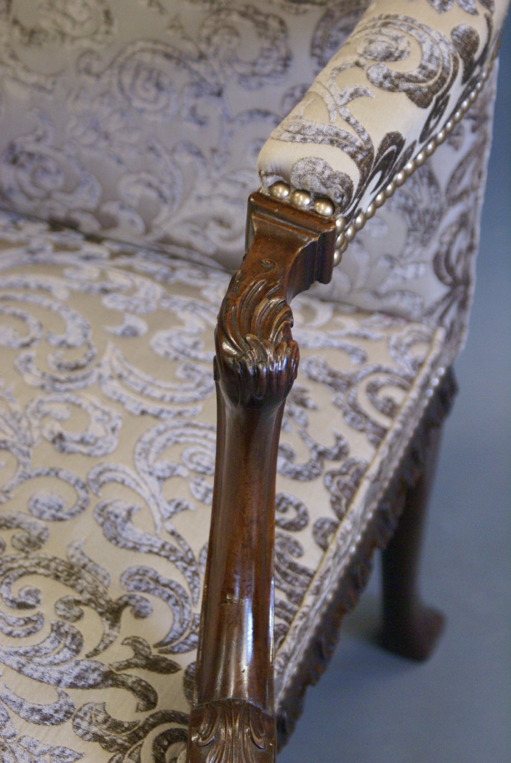 A George II style mahogany Gainsborough library armchair upholstered in a patterned taupe fabric with carved cabriole legs and scroll feet. View IV