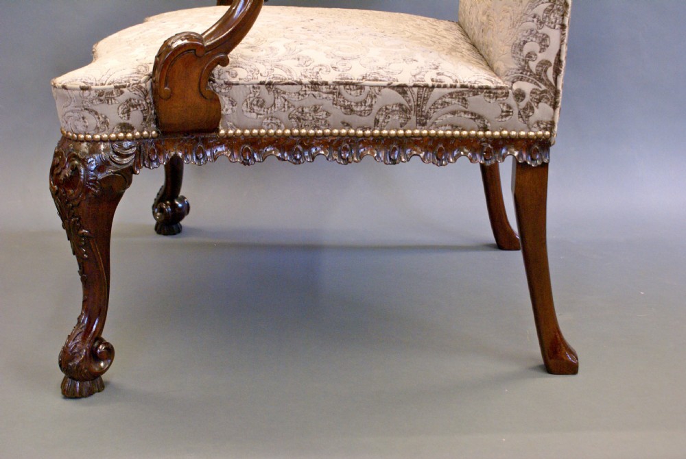 A George II style mahogany Gainsborough library armchair upholstered in a patterned taupe fabric with carved cabriole legs and scroll feet. View VII