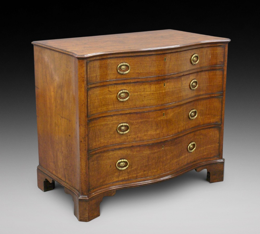 A George III mahogany serpentine chest View II
