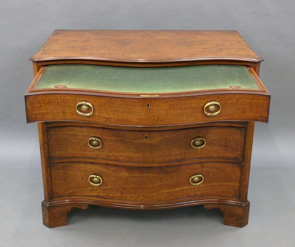 A George III mahogany serpentine chest View IV