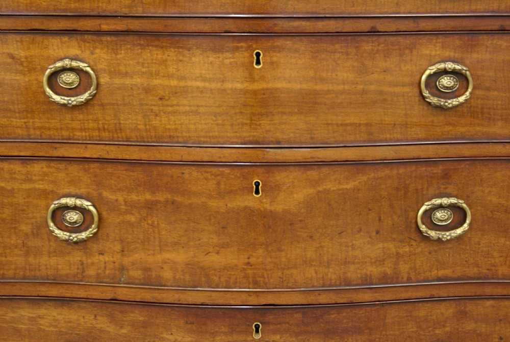 A George III mahogany serpentine chest View VI