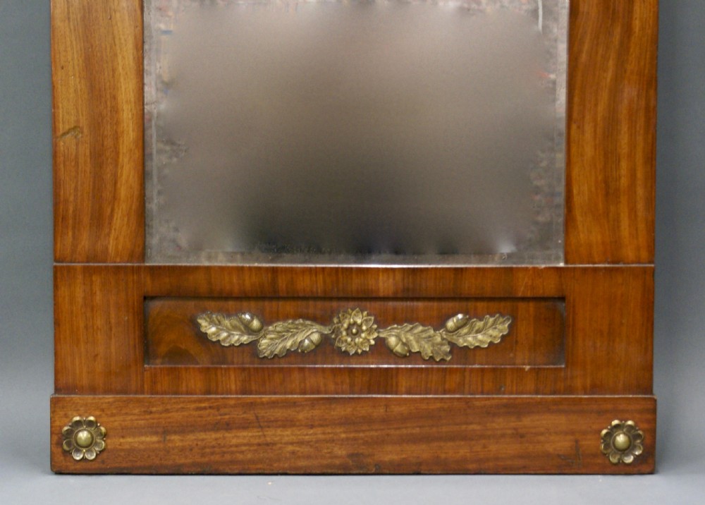 An Empire period mahogany wall mirror featuring a pedimented crest, classical ormolu rosettes, and a central gilded winged lion mount. View III