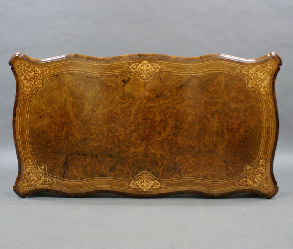 An English burr walnut bureau plat featuring gilt bronze ormolu mounts, a serpentine top, frieze drawers, and cabriole legs. View VI