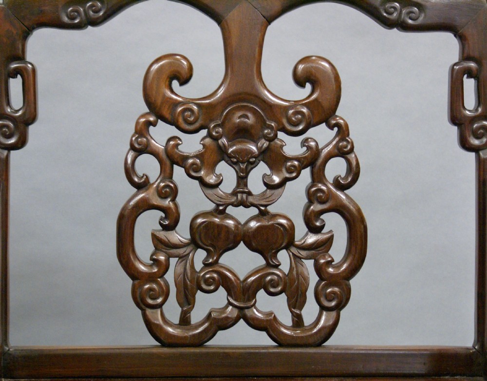 A pair of antique Chinese Qing dynasty dark hongmu armchairs featuring intricately carved openwork back splats and square mortise-and-tenon construction. View II