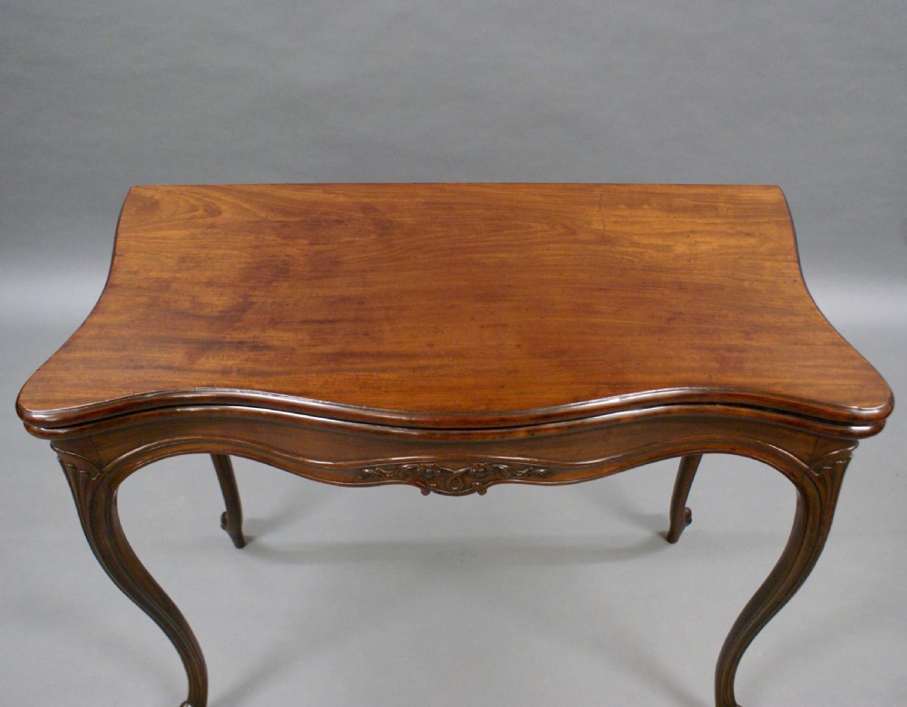A dark mahogany Hepplewhite period serpentine-front card table featuring carved cabriole legs and scroll feet. View IV