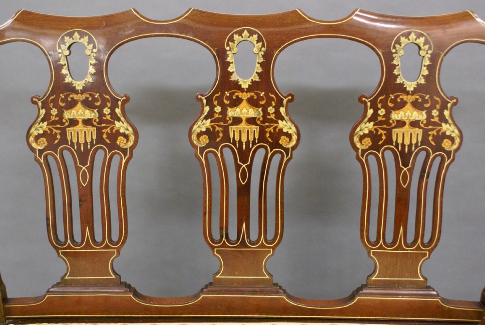 A late nineteenth-century mahogany triple chair-back salon settee with marquetry urn inlays and a patterned cream upholstered seat. View III
