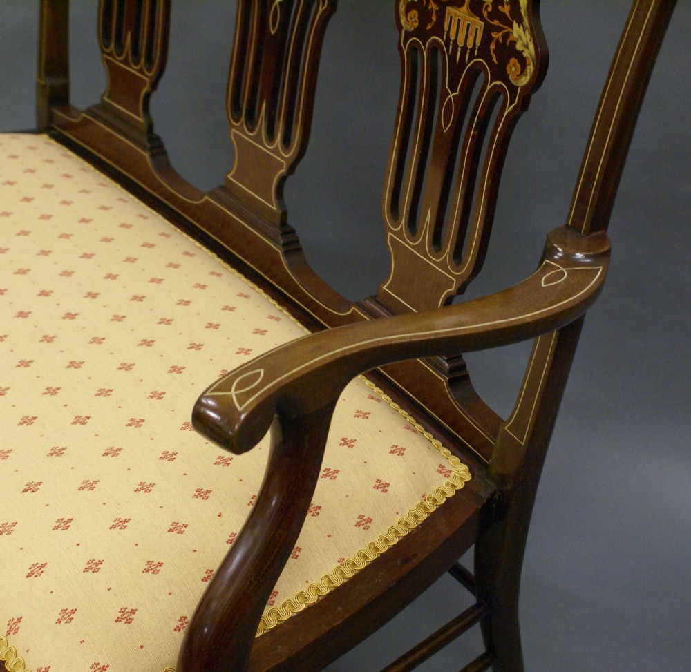 A late nineteenth-century mahogany triple chair-back salon settee with marquetry urn inlays and a patterned cream upholstered seat. View VI