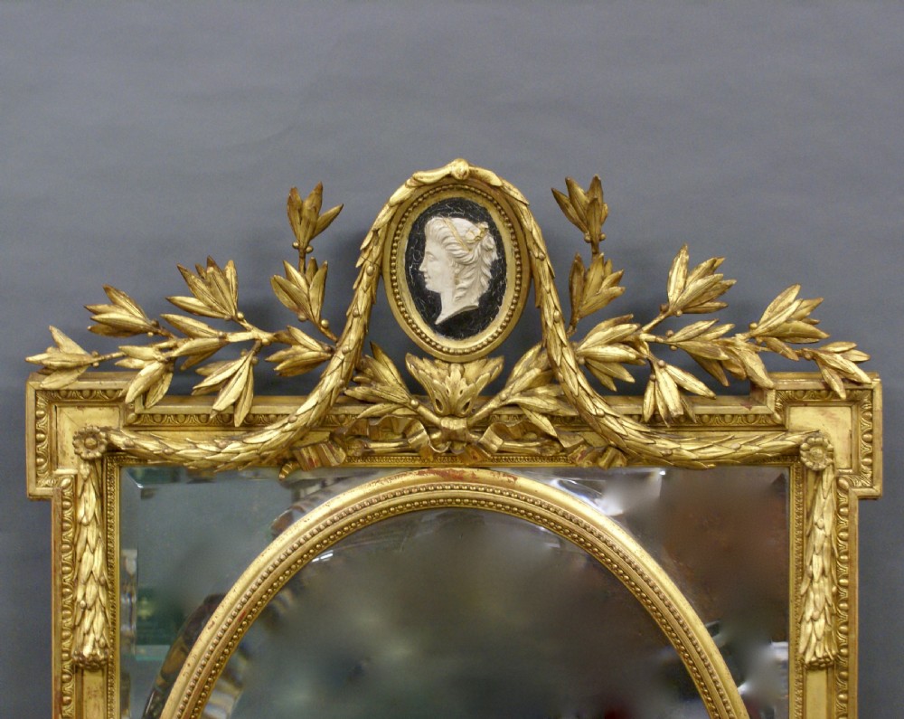 A rectangular French gilt wall mirror featuring an oval inner bevelled frame, laurel foliage crest, and a top medallion containing a profile cameo. View II