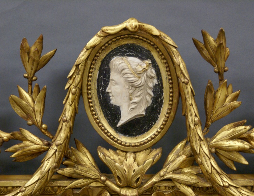 A rectangular French gilt wall mirror featuring an oval inner bevelled frame, laurel foliage crest, and a top medallion containing a profile cameo. View VII