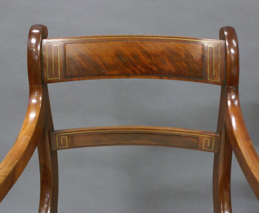 A pair of Regency mahogany brass inlaid arm chairs View V
