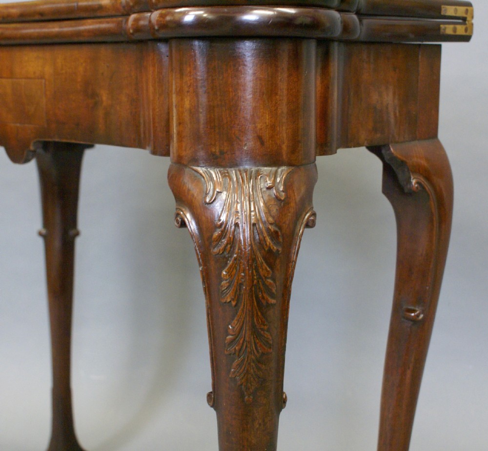 A George II mahogany fold-over tea table featuring a serpentine top and carved cabriole legs. View II