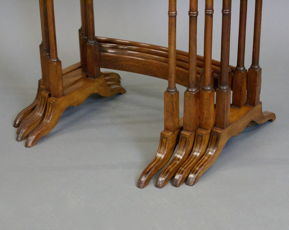 A set of four Edwardian quartetto nesting tables featuring burr walnut tops, thin inlay, slender turned legs, and arched stretchers on trestle feet. View V