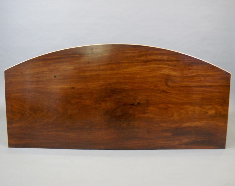 A George III mahogany sideboard featuring boxwood stringing, brass oval drop handles, a central arched apron, and tapered legs ending in spade feet. View III