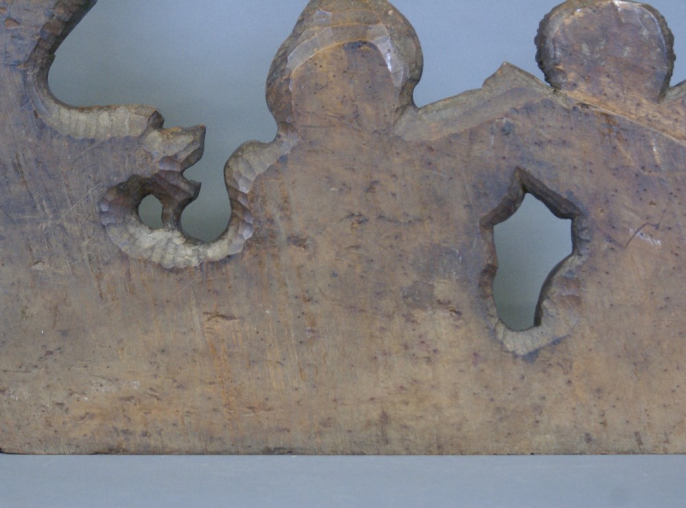 A 17th-century carved walnut architectural relief featuring two sculpted putti figures, a central cartouche shield, and a winged mythical beast. View VII