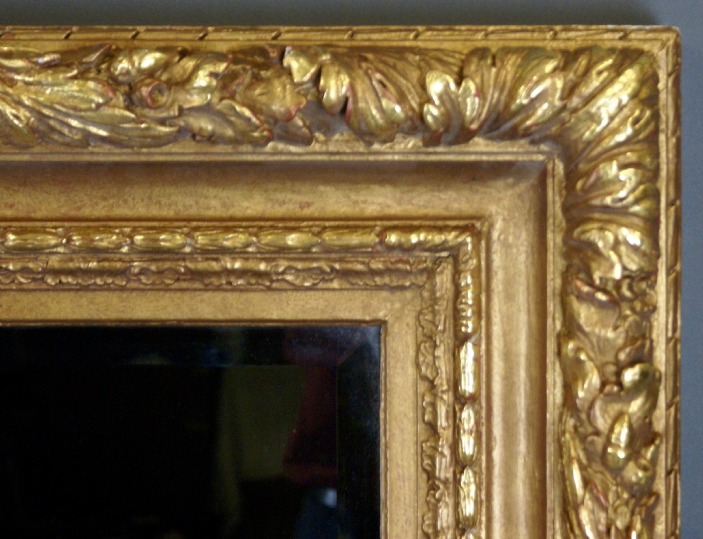 A large rectangular wall mirror featuring an ornate golden giltwood frame with detailed leaf carvings and bevelled glass. View II
