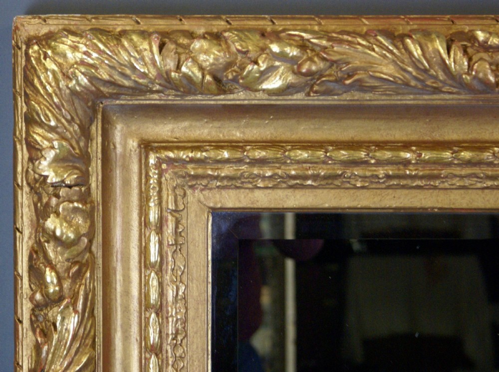 A large rectangular wall mirror featuring an ornate golden giltwood frame with detailed leaf carvings and bevelled glass. View III