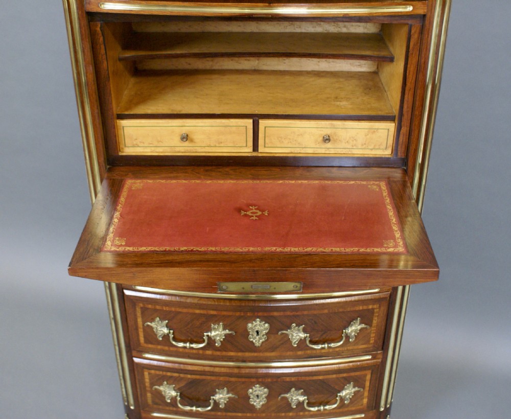 A tall French rosewood chest featuring geometric parquetry inlay, six drawers with gilt brass handles, fluted corner columns, and a shaped pink marble top. View IV