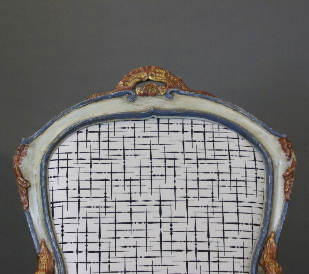 A pair of 18th-century Italian Barocchetto armchairs with pale blue carved wooden frames, red accents, and patterned fabric upholstery. View IV
