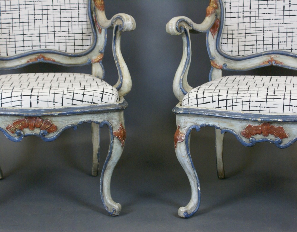 A pair of 18th-century Italian Barocchetto armchairs with pale blue carved wooden frames, red accents, and patterned fabric upholstery. View V
