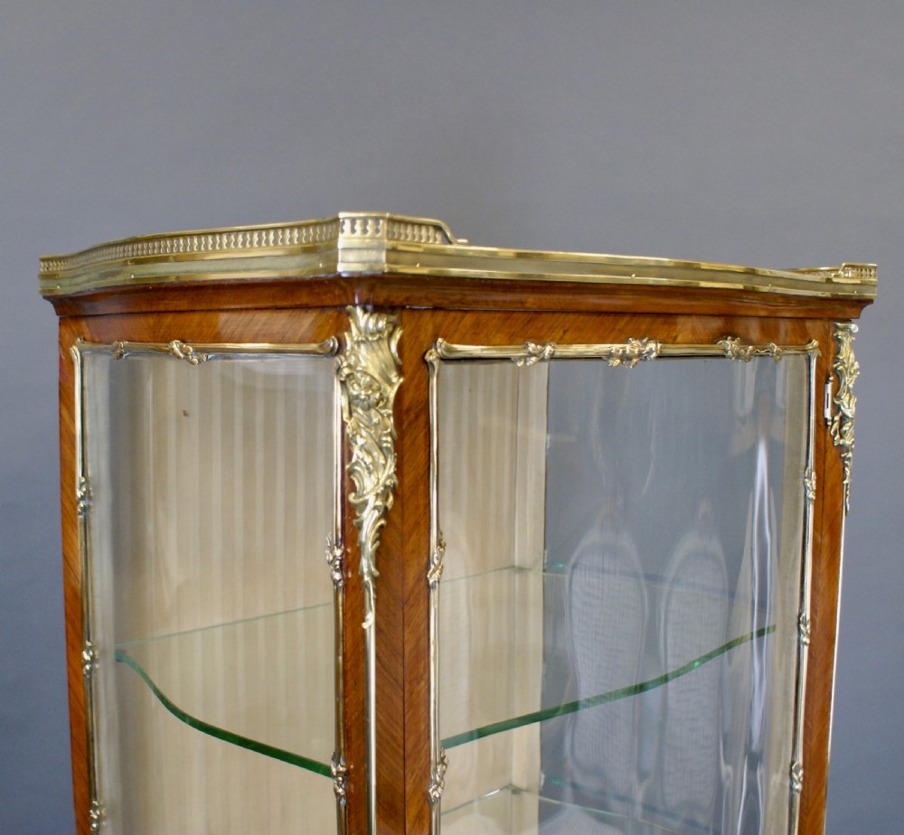 A tall French Louis XV style glazed vitrine featuring parquetry wood veneer, curved glass panels, polished brass ormolu mounts, and slender cabriole legs. View III