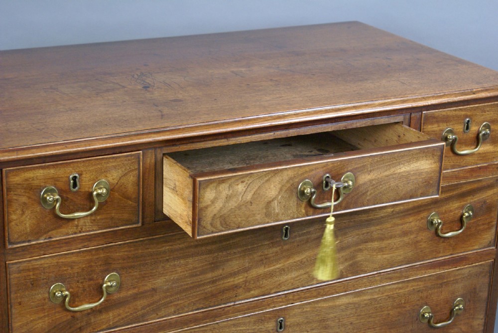 A Georgian mahogany chest of drawers featuring three small top drawers over three long graduating drawers with brass swan-neck handles and bracket feet. View III