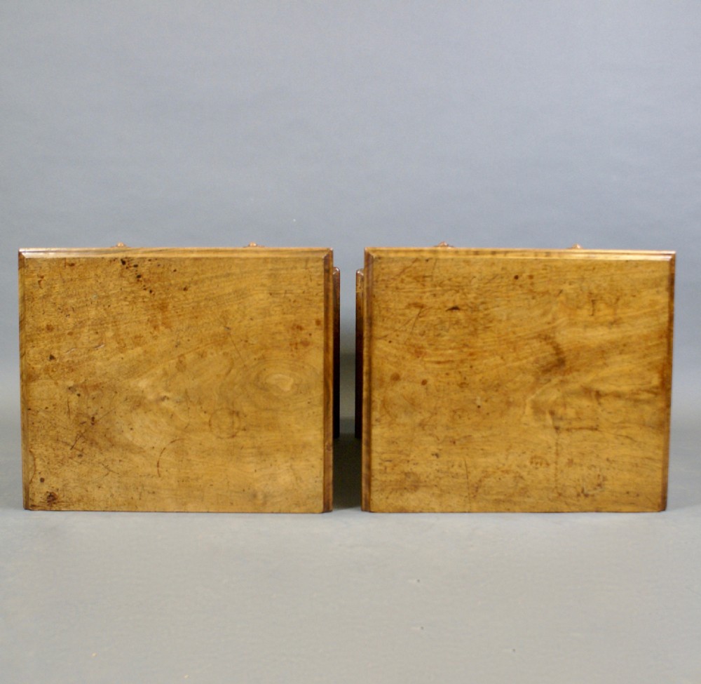 A pair of matching late 19th-century walnut chests featuring four drawers each with turned wooden knobs and a solid plinth base. View V