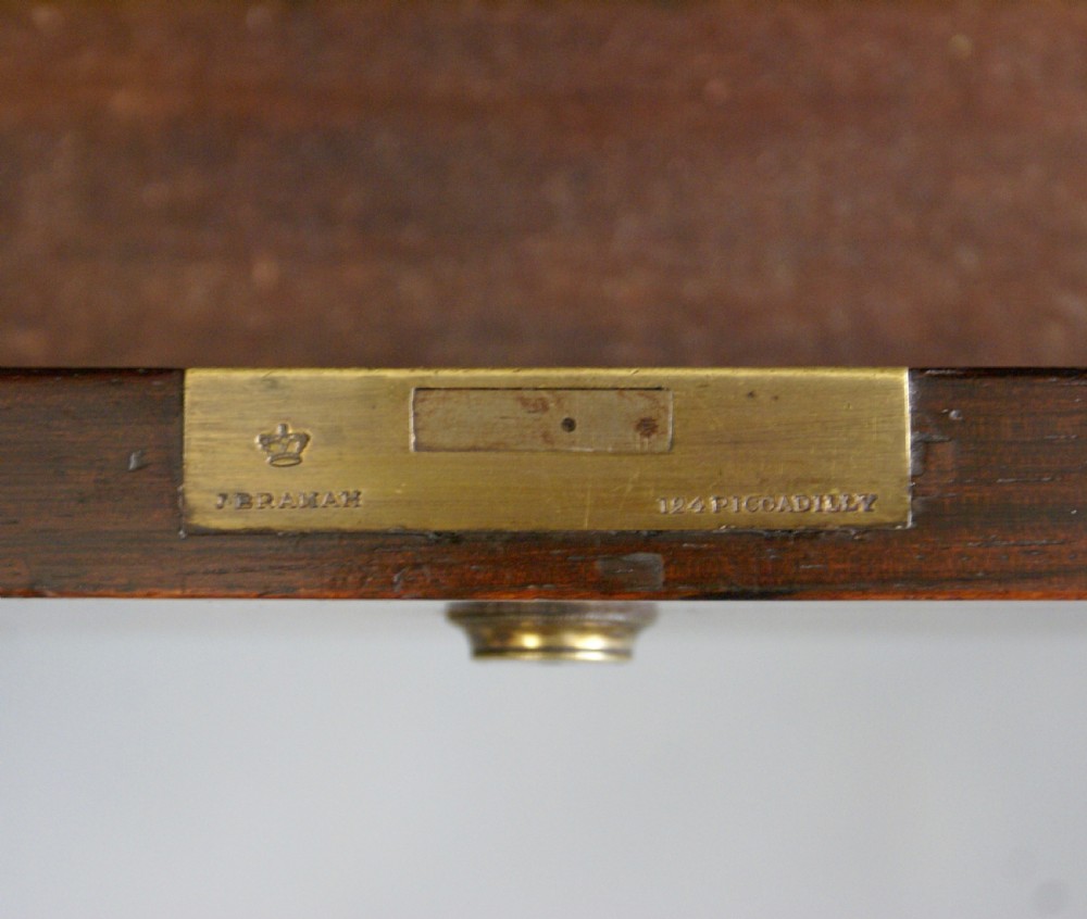 A Regency rosewood Davenport desk featuring a sloped green leather top, brass spindle gallery, four side drawers, and turned feet. View V