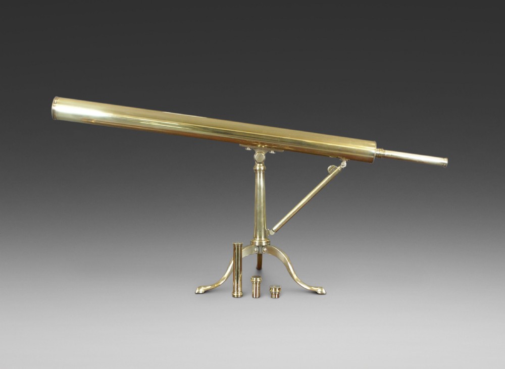 A nineteenth-century Victorian brass library telescope mounted on a tripod pillar stand alongside three additional brass eyepiece attachments.