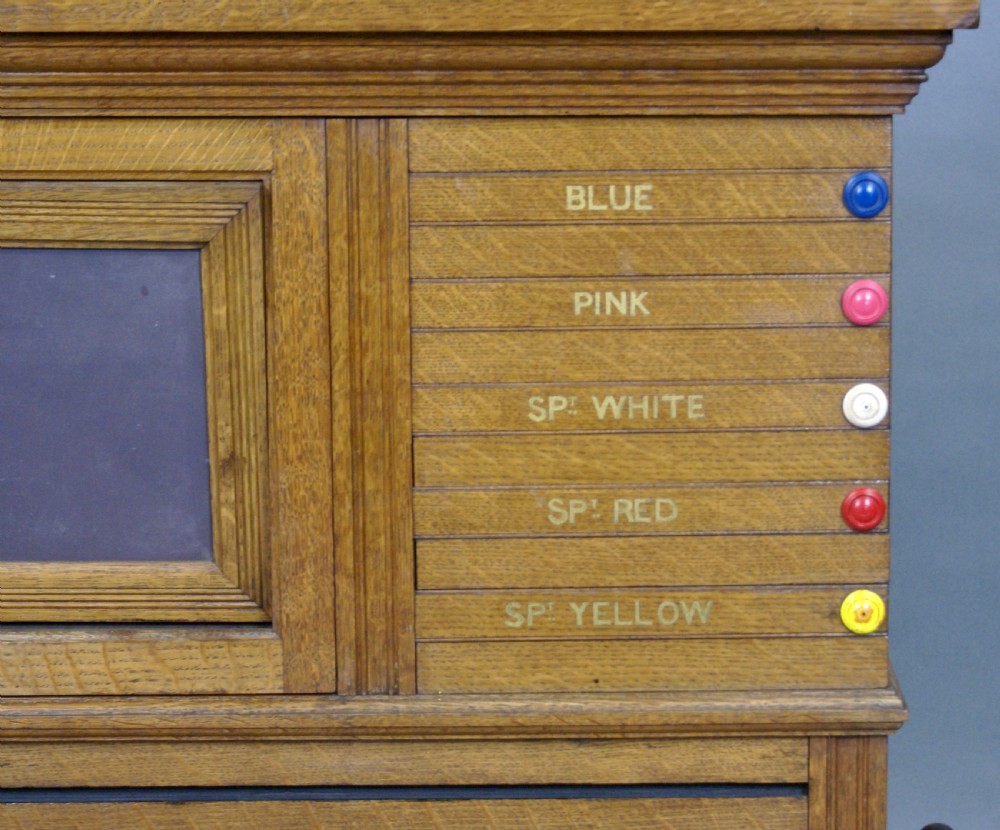 An antique pale oak wall-mounted snooker scoreboard featuring a carved pediment, sliding colour markers, central slate panel, and numbered rolling dials. View VI