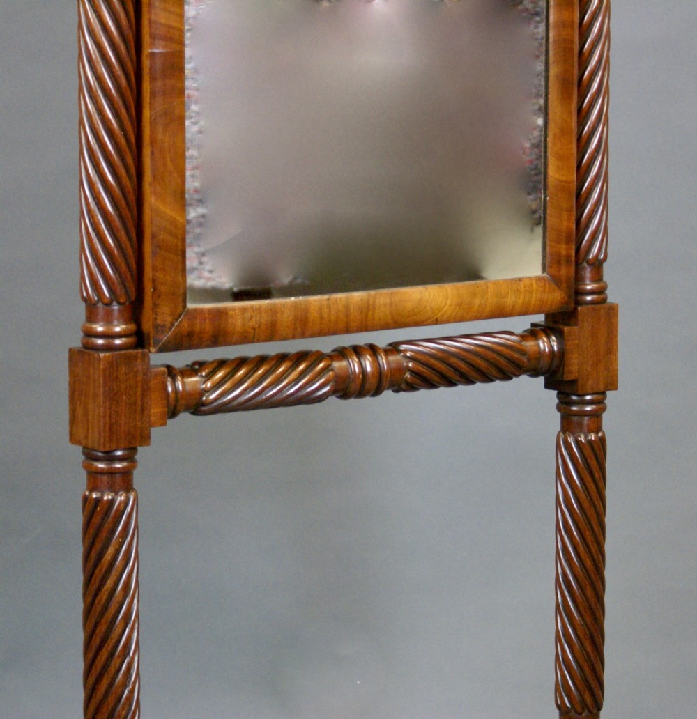 A William IV mahogany cheval mirror featuring spiral-carved support columns, a tilting rectangular glass frame, and splayed legs fitted with brass castors. View VI