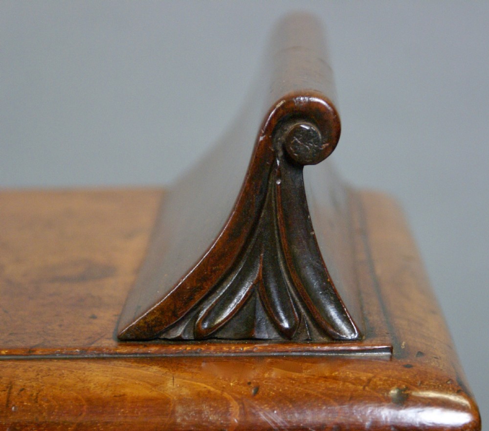 An antique wooden window seat with fluted turned legs and scroll ends on a neutral background. View III
